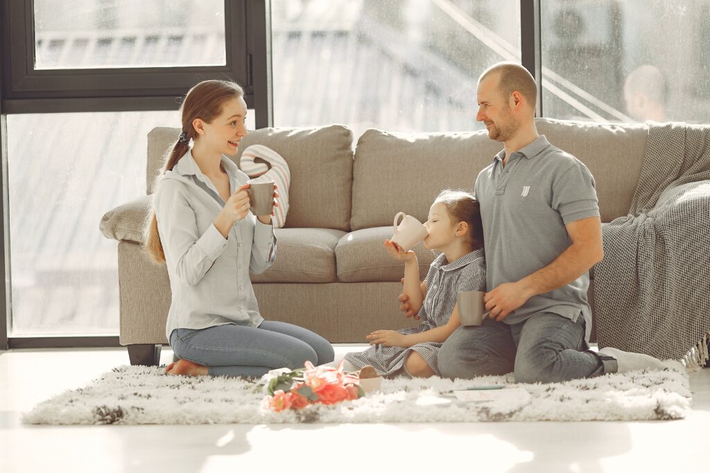 Famille jouant ensemble sur un tapis dans le salon